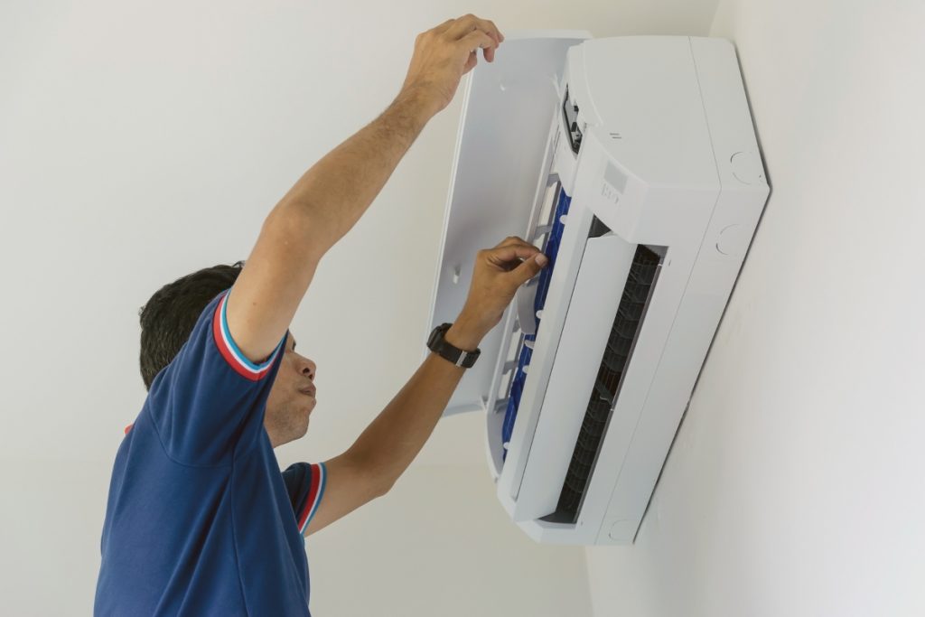 A technician assessing overall conditions of wall mounted aircon